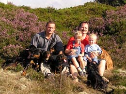 Hunde und Männer und Kinder vor Heidekraut